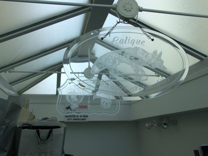 Looking up at the glass roof with two rare glass advertisment hangers, the one at the front showing Renard (Fox) with etched 'Lalique Mascottes Automobiles'.